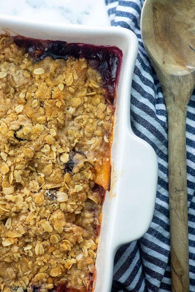 baked peach crisp in white baking dish