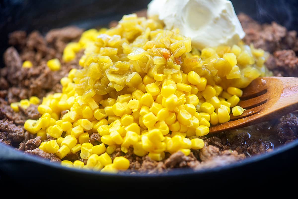 corn and cream cheese in skillet with taco meat.