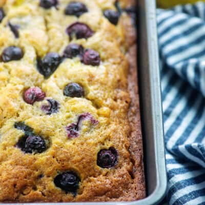 A close up of a banana blueberry bread cooked on a baking sheet.