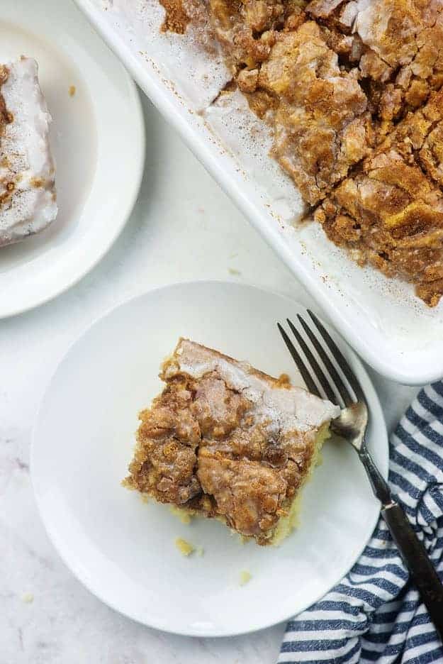 cinnamon roll cake on white plate with blue napkin