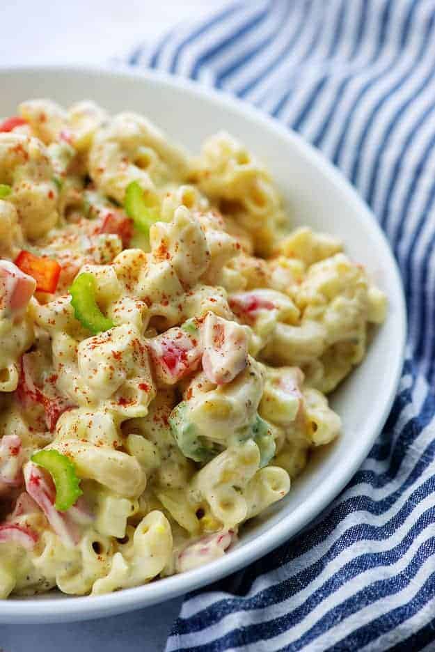 amish macaroni salad recipe in white bowl with blue striped napkin