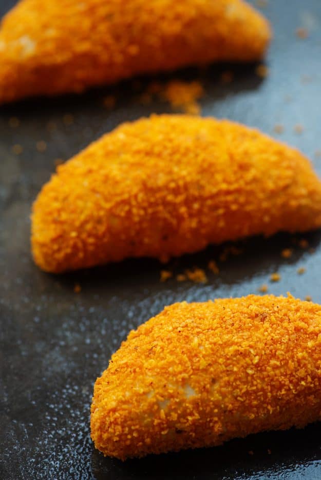 crispy baked chicken taco pockets coated in nacho cheese doritos on baking sheet