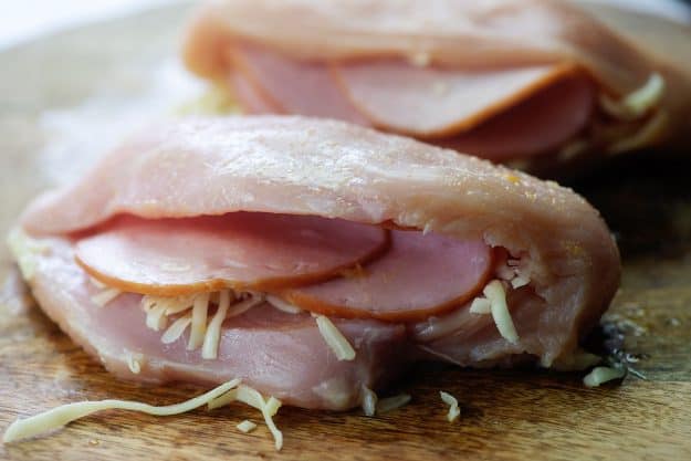 chicken stuffed with ham and mozzarella on cutting board