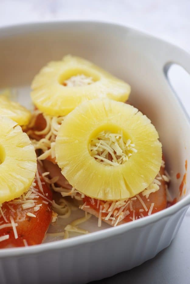 chicken topped with cheese and pineapple in baking dish