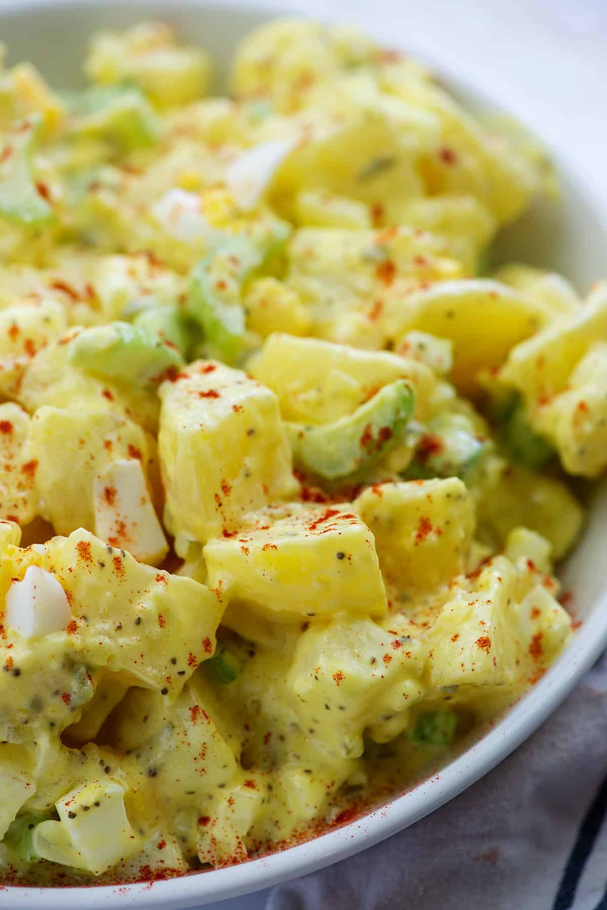 potato salad with celery in white bowl