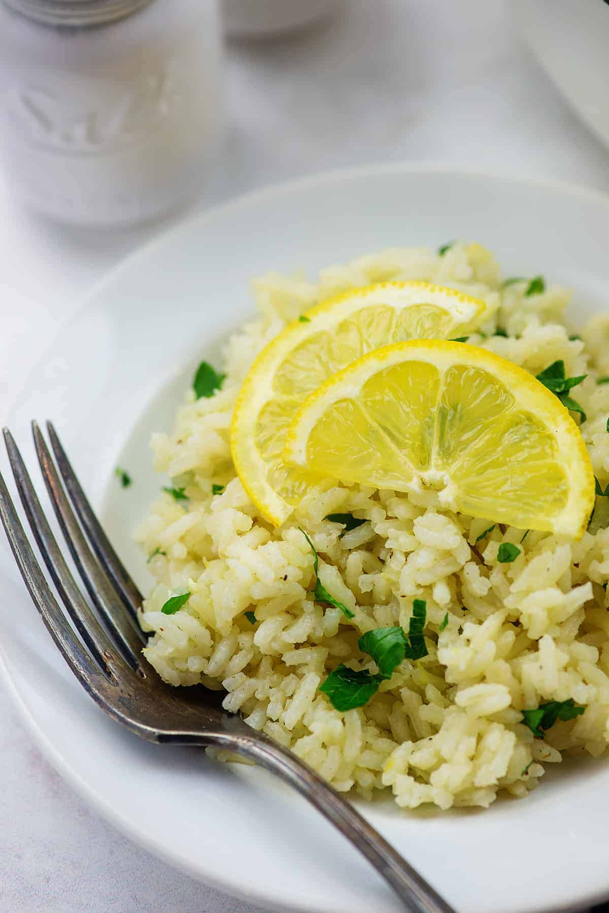 greek lemon rice on white plate with vintage fork