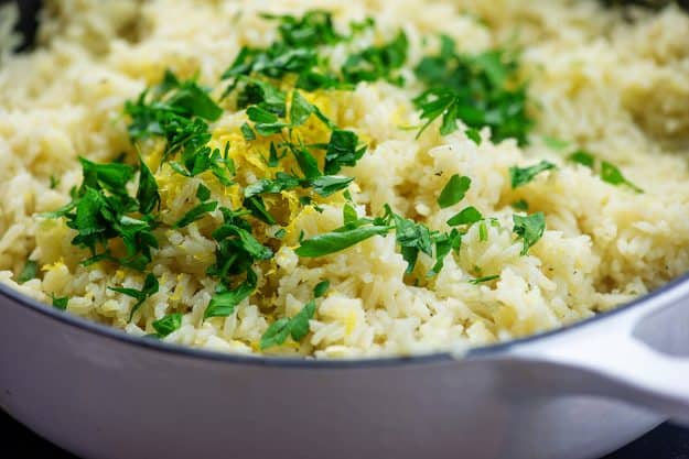 rice with lemon zest and parsley in white cast iron skillet