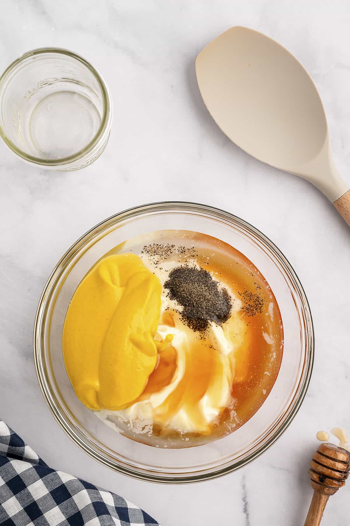 Ingredients for homemade honey mustard dressing in mixing bowl.