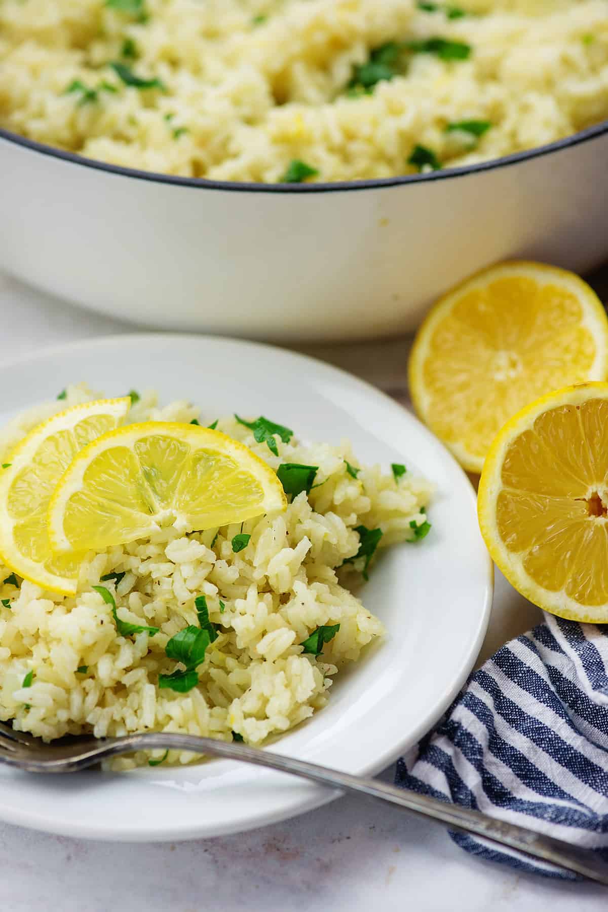 greek rice recipe on white plate with blue striped napkin and vintage fork