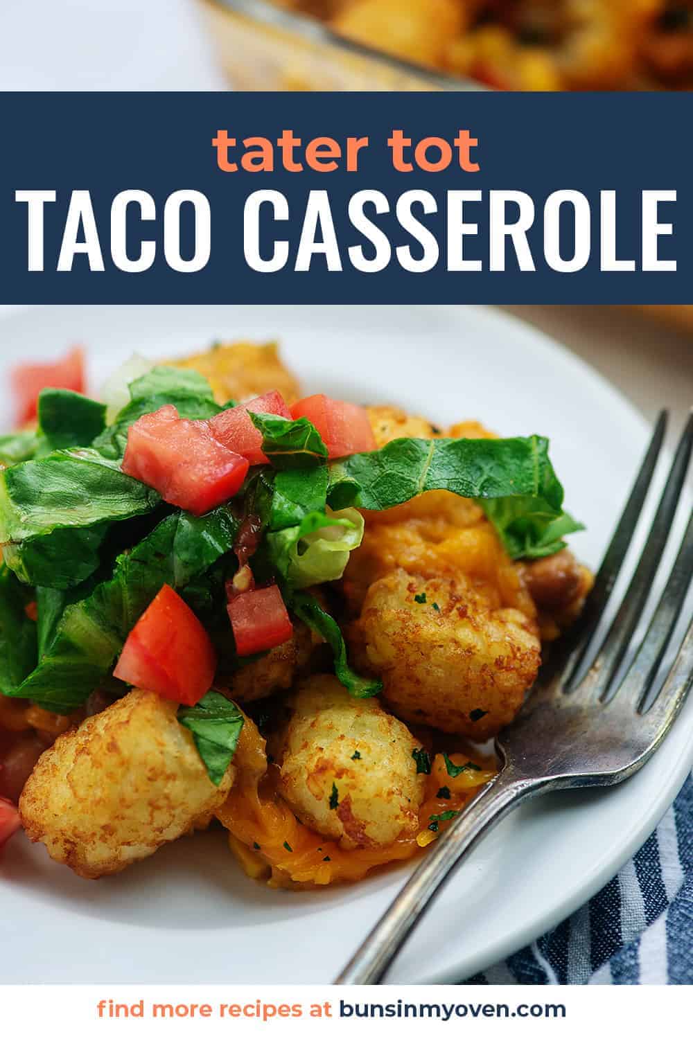 mexican tater tot casserole on white plate with lettuce and tomatoes