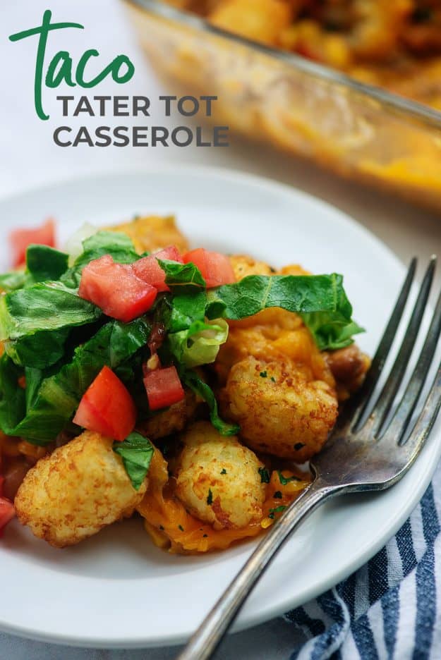 tater tot casserole on white plate with lettuce and tomatoes