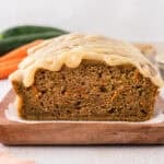 Glazed zucchini carrot bread on wooden board.