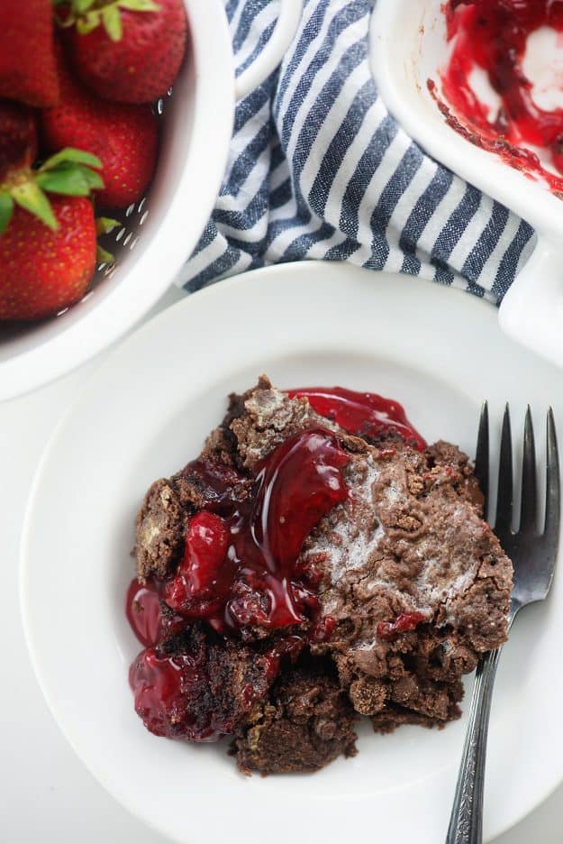 chocolate strawberry cake on white plate with blue striped napkin