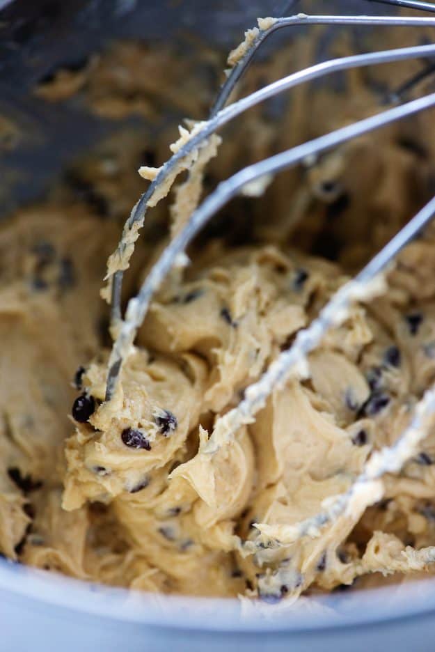 frosting with chocolate chips in mixing bowl on wire whisk