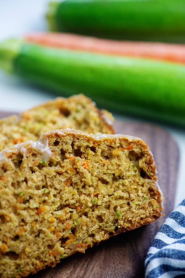 sliced bread on wooden cutting board with zucchini and carrots