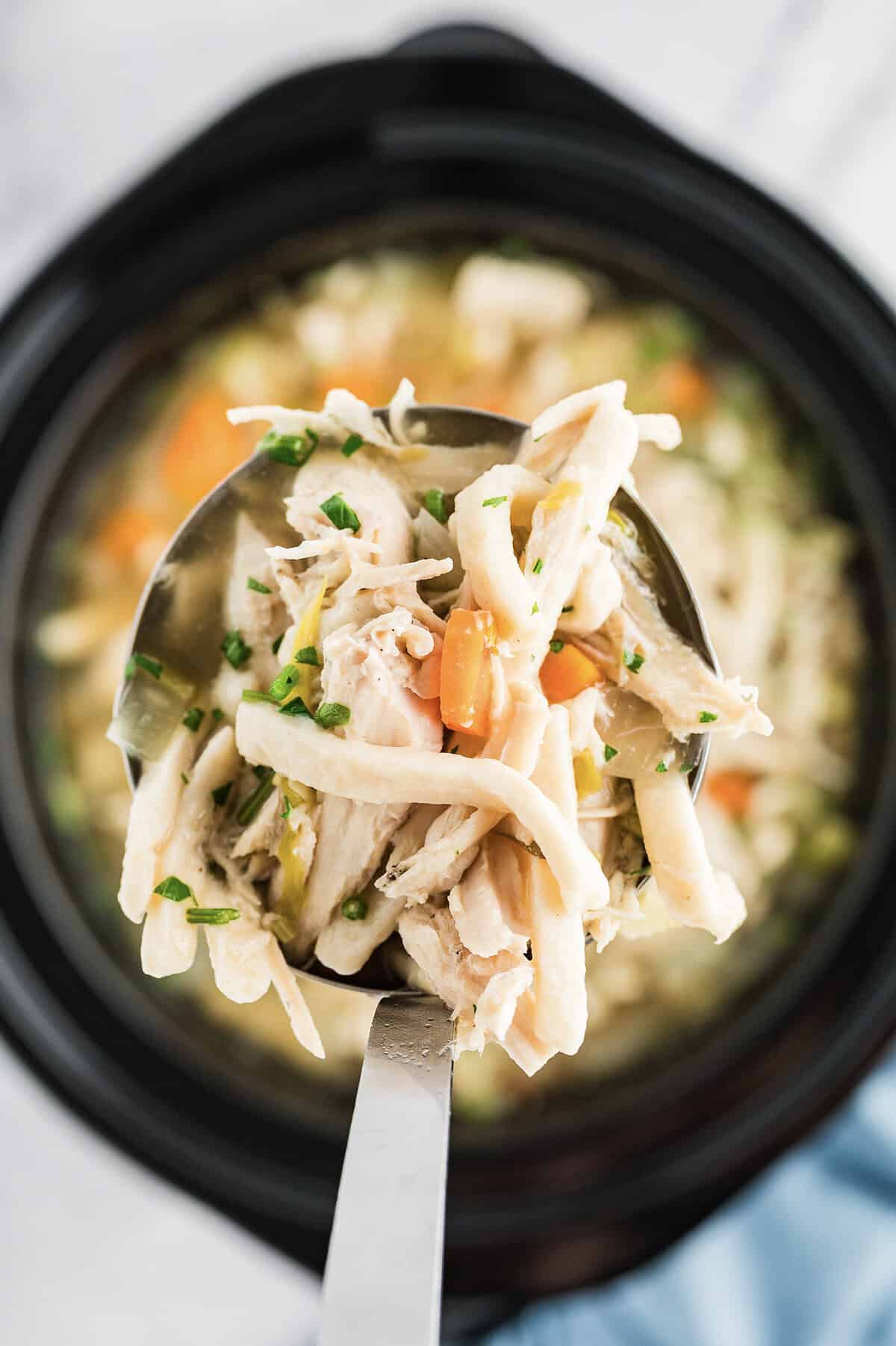Ladle full of slow cooker chicken noodle soup recipe.