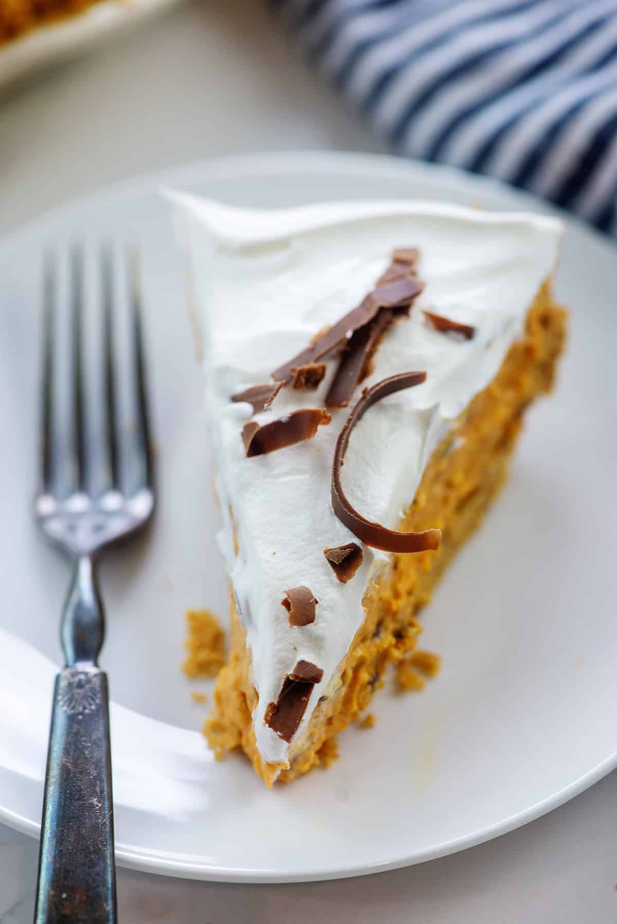 pumpkin chip pie topped with whipped cream on white plate