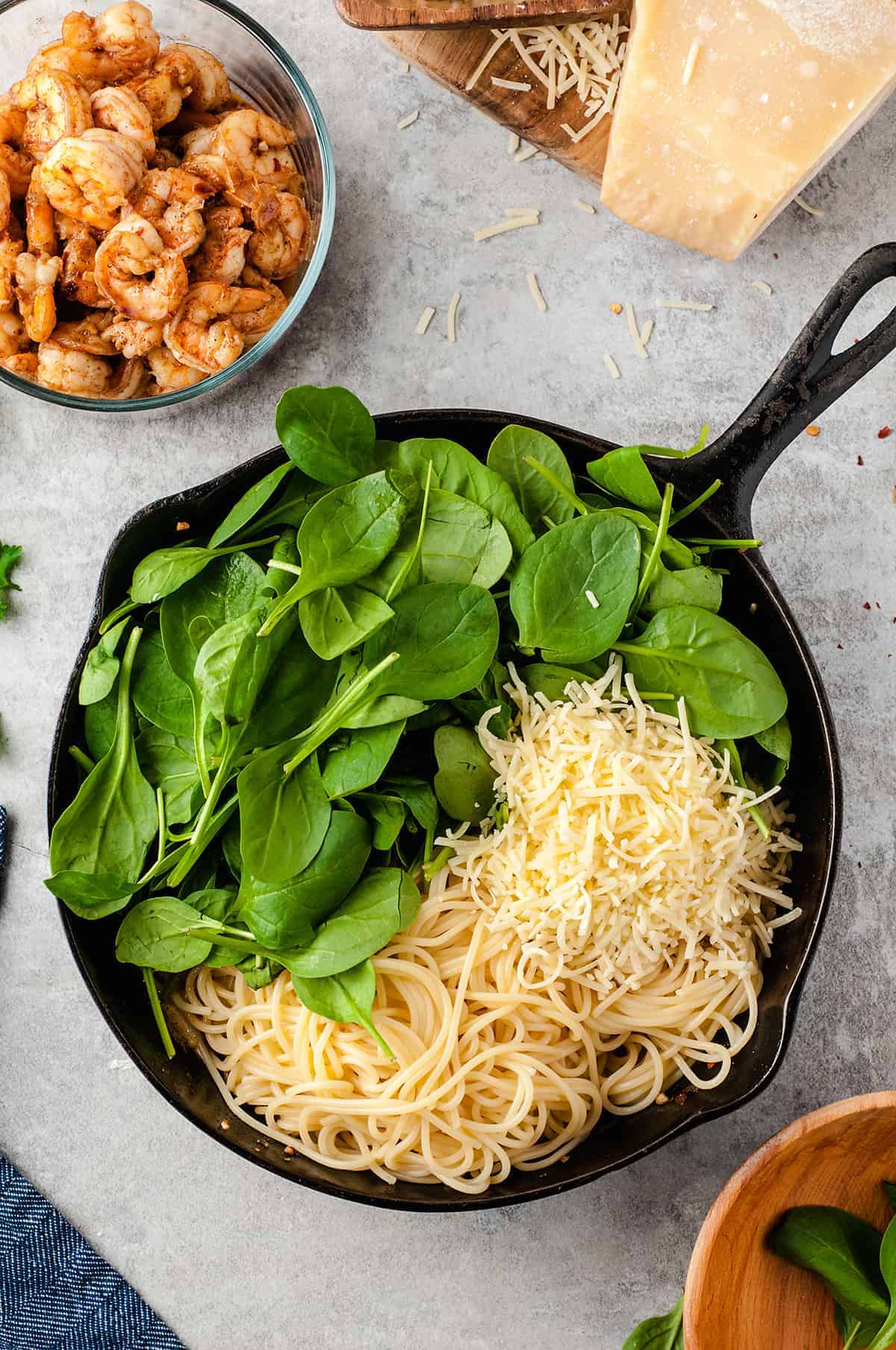 pasta, parmesan, and spinach in cast iron skillet