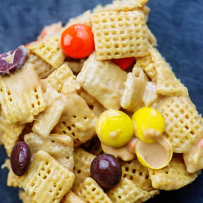 peanut butter chex bars with reese's pieces on slate background