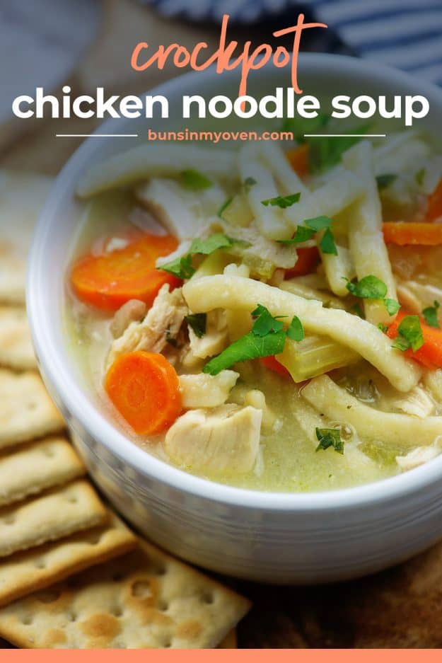 chunky chicken noodle soup in white bowl surrounded by crackers
