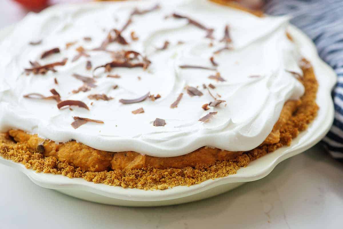 pumpkin pie topped with cool whip and chocolate shavings