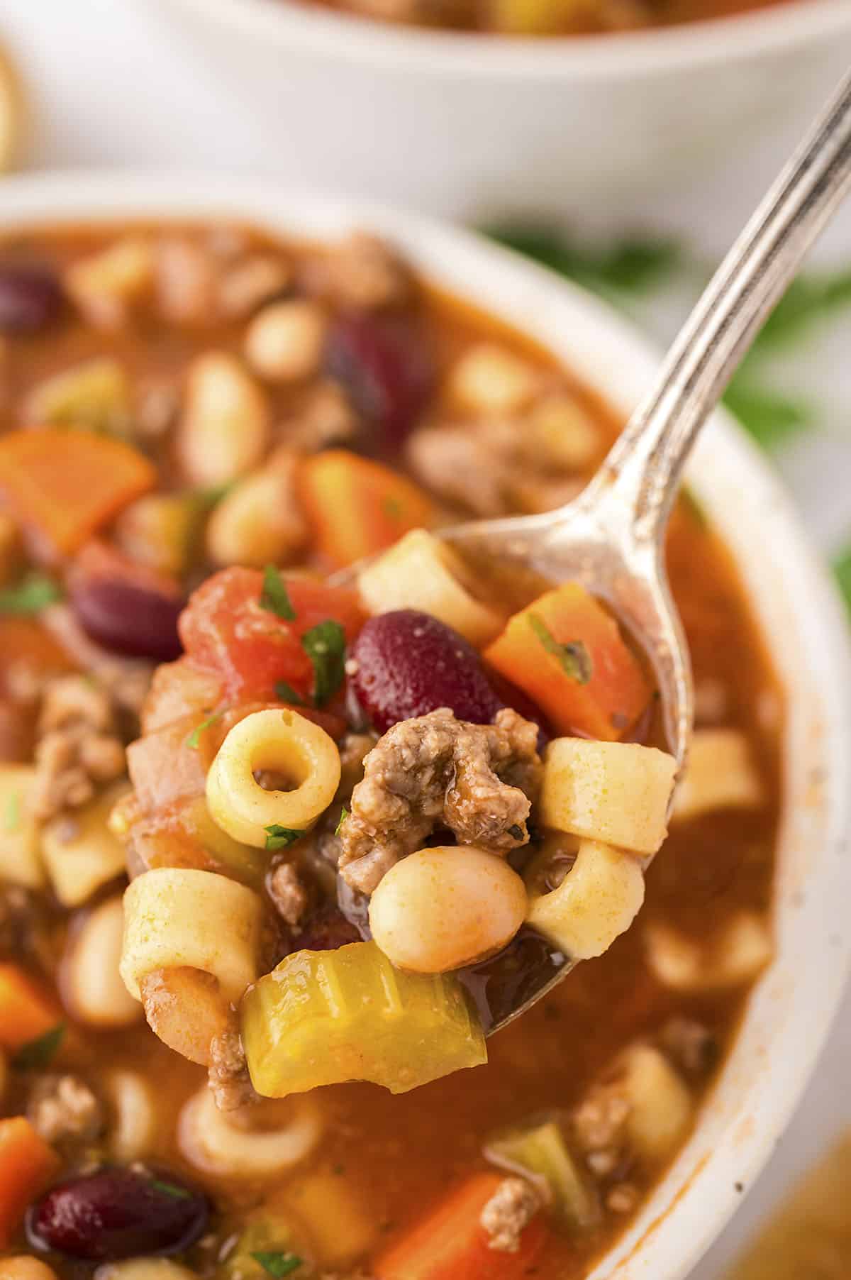 Olive Garden pasta fagioli soup recipe on spoon over bowl.