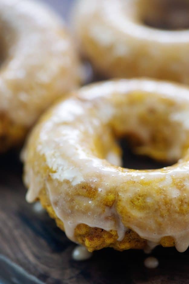 glazed pumpkin donuts on wooden cutting board