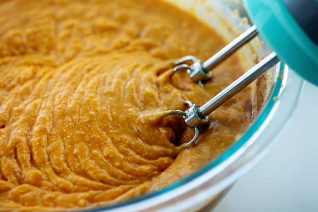 creamy pumpkin pudding mixture in glass bowl with mixer