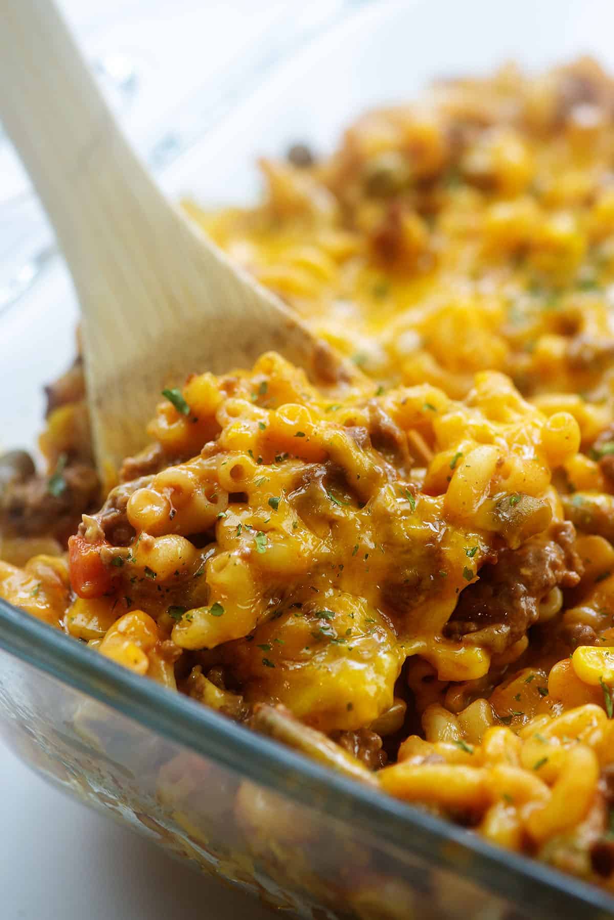 spoon full of casserole in baking dish.