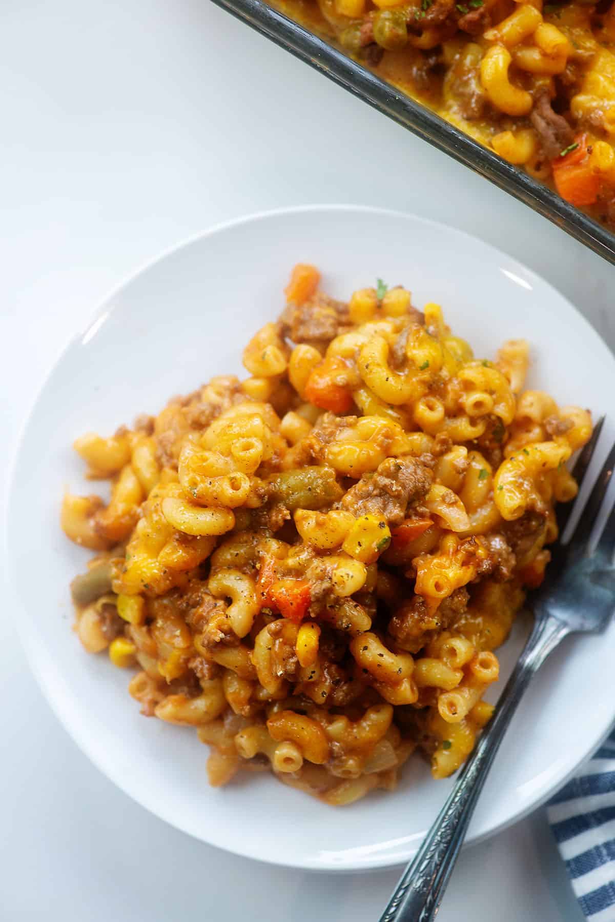 white plate full of cheesy macaroni and beef casserole.