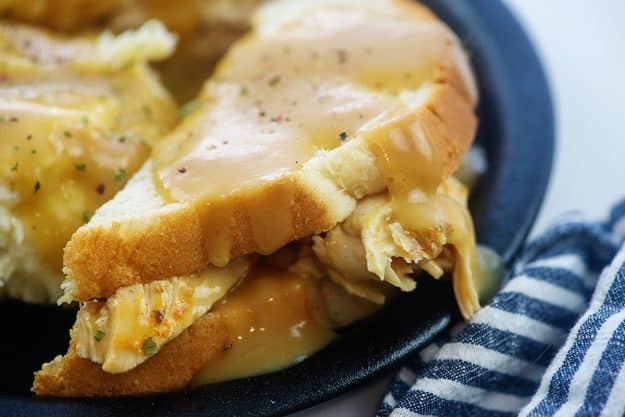 turkey sandwich topped with gravy.