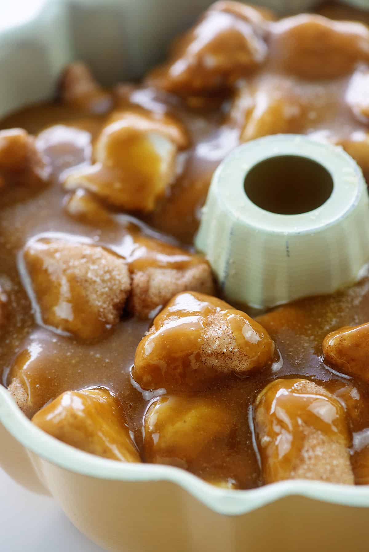 biscuit dough in bundt pan coated in caramel sauce.