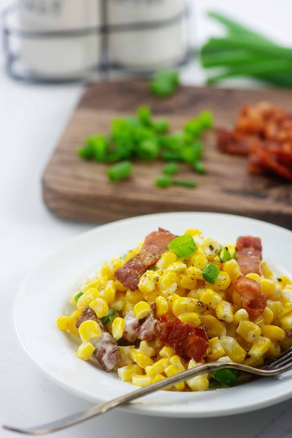 corn with cream cheese on white plate.