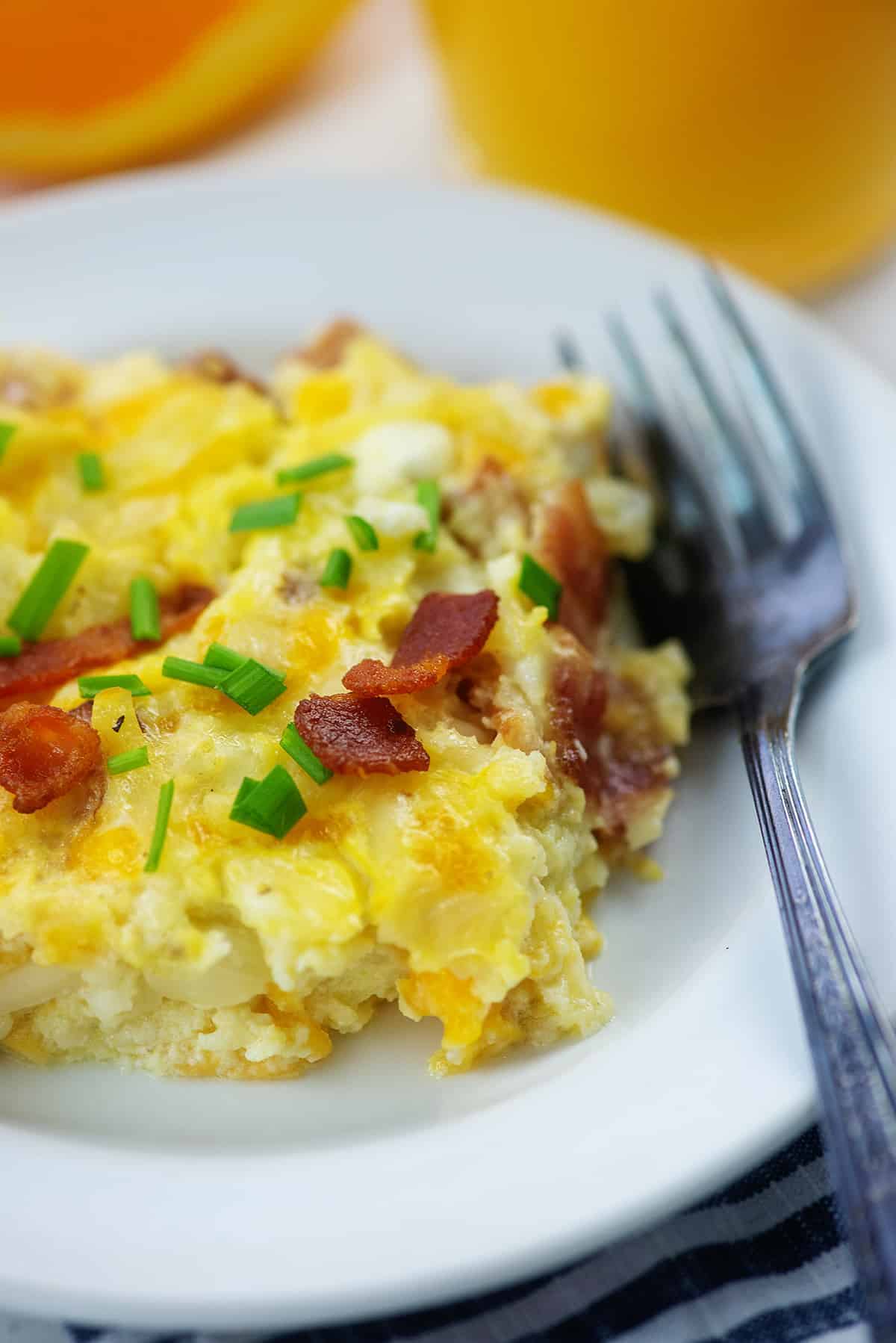 slice of Amish breakfast casserole  on white plate with fork.