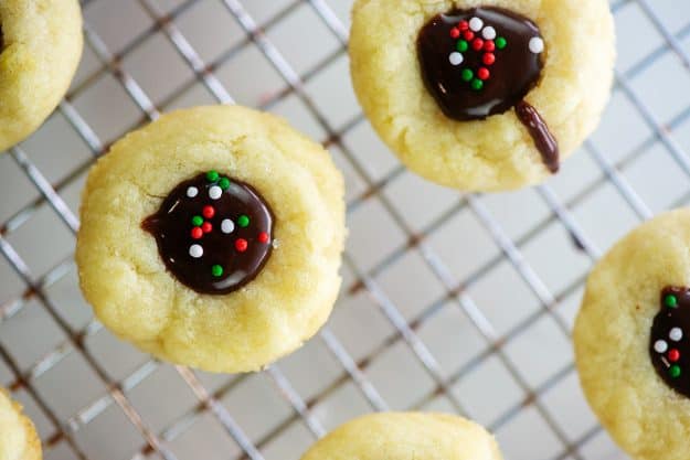 chocolate thumbprints on cooling rack with sprinkles.