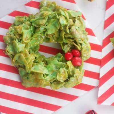 green cornflake wreath cookies on striped paper.