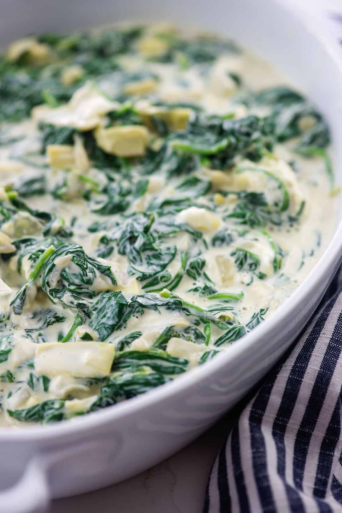 creamed spinach mixture in white baking dish.