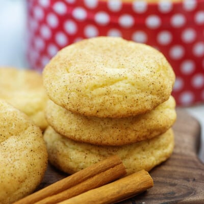 stack of thick snickerdoodle cookies on wooden board.