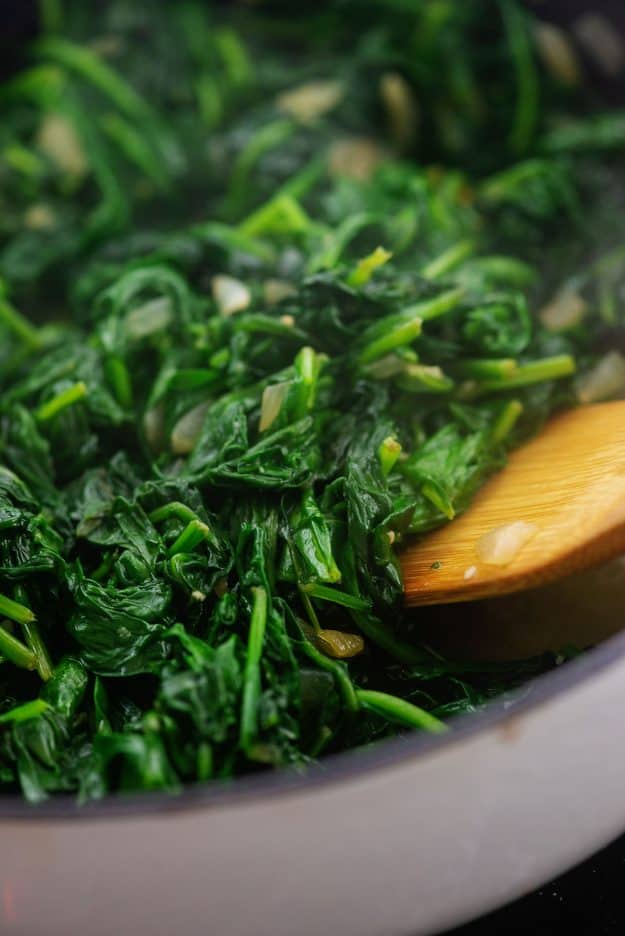 cooked spinach in white pot.