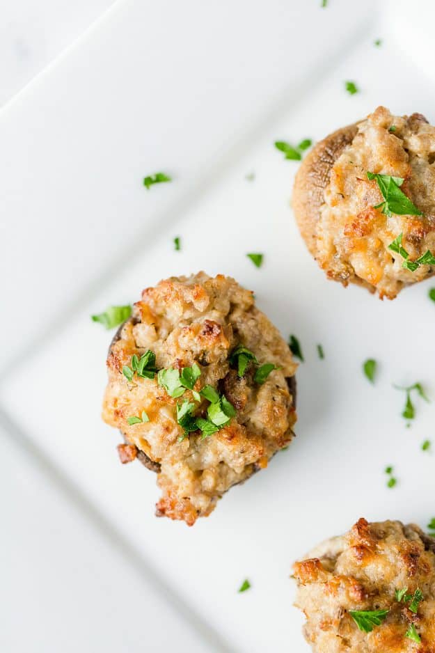 sausage stuffed mushrooms on white plate.