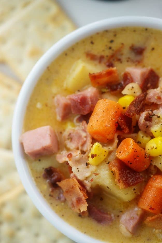 overhead view of ham and corn chowder in white bowl.