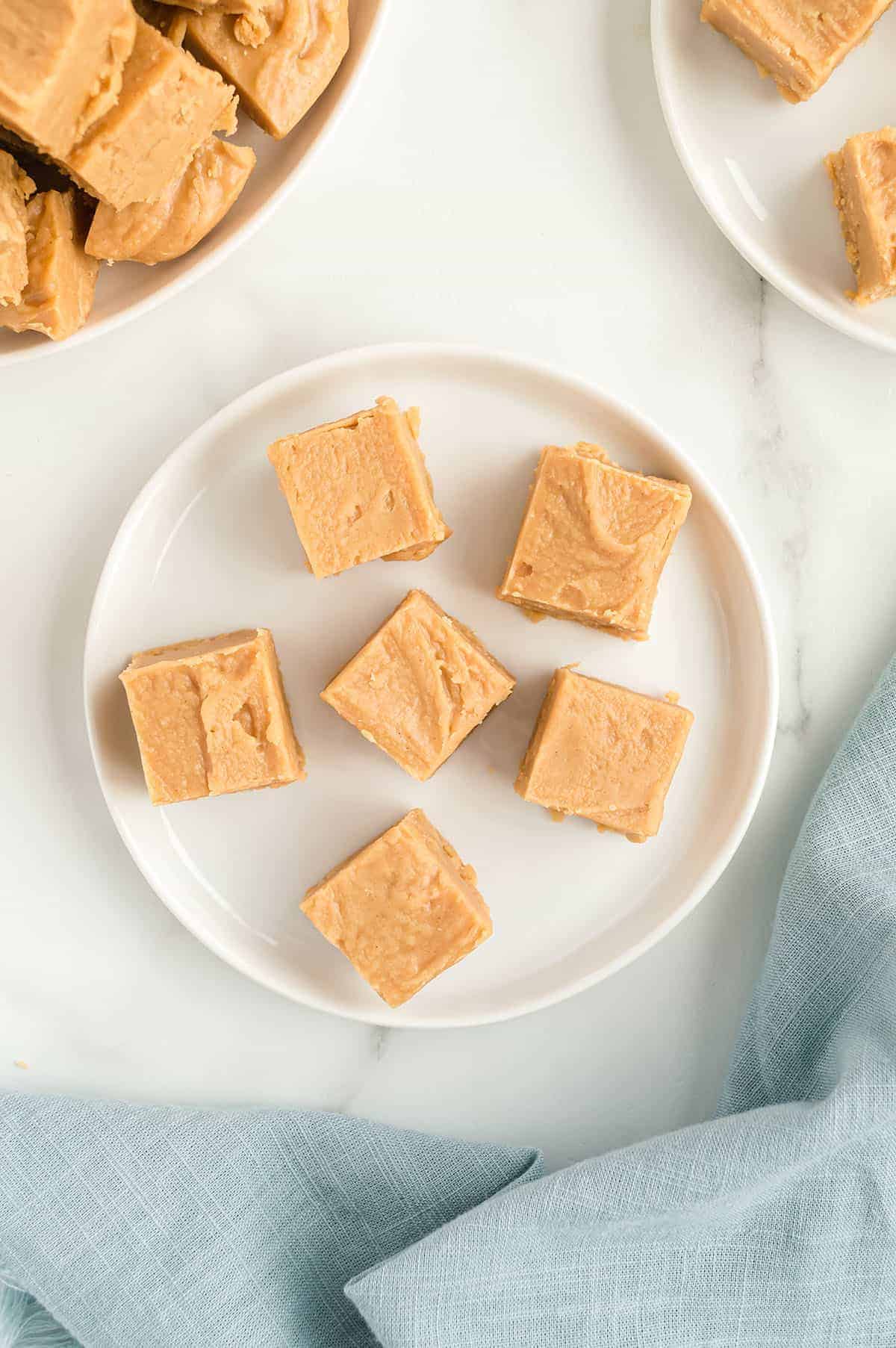 easy peanut butter fudge recipe on white plate.