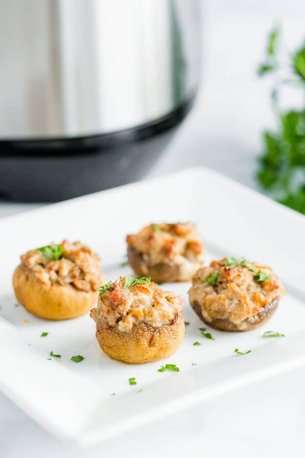 Sausage stuffed mushrooms on a white plate.