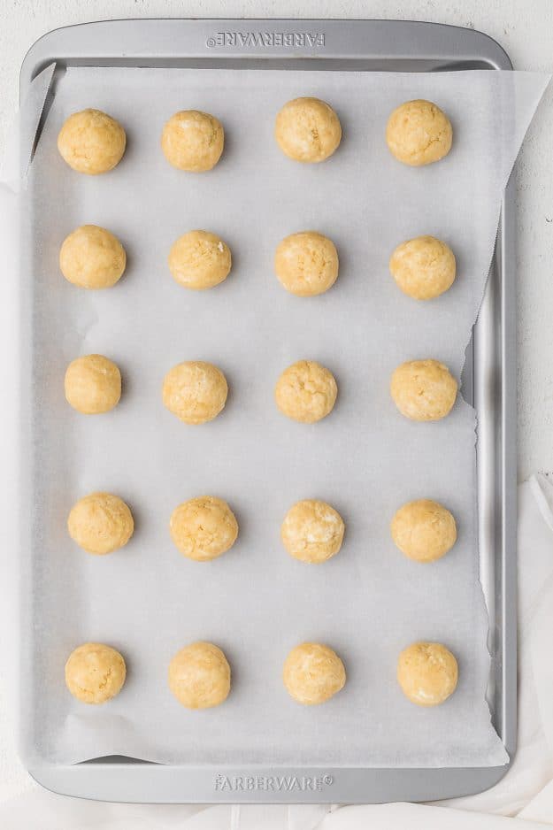 overhead view of cookie balls on baking sheet.