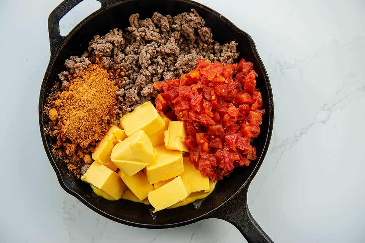 ingredients for rotel dip in cast iron skillet.