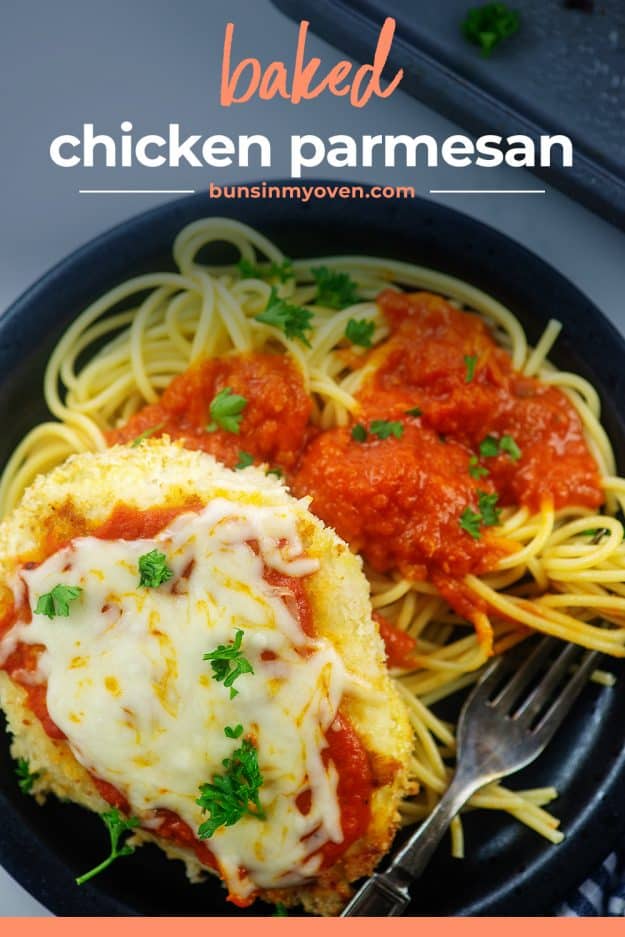 overhead view of chicken parmesan and spaghetti on black plate.