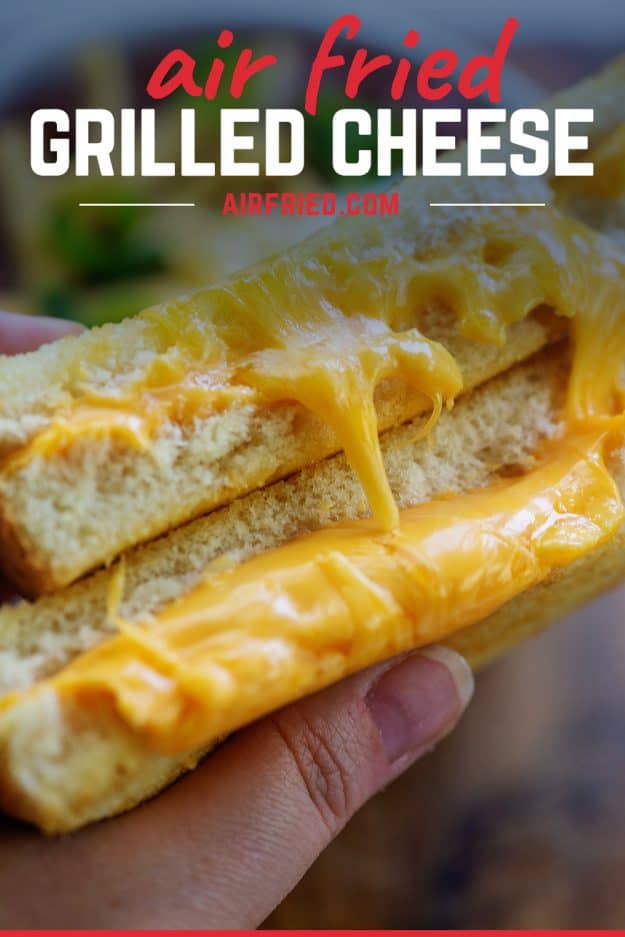 person holding an ultra cheesy grilled cheese sandwich.