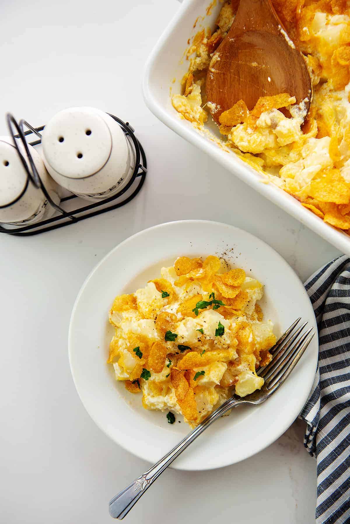 overhead view of funeral potatoes on white countertop.