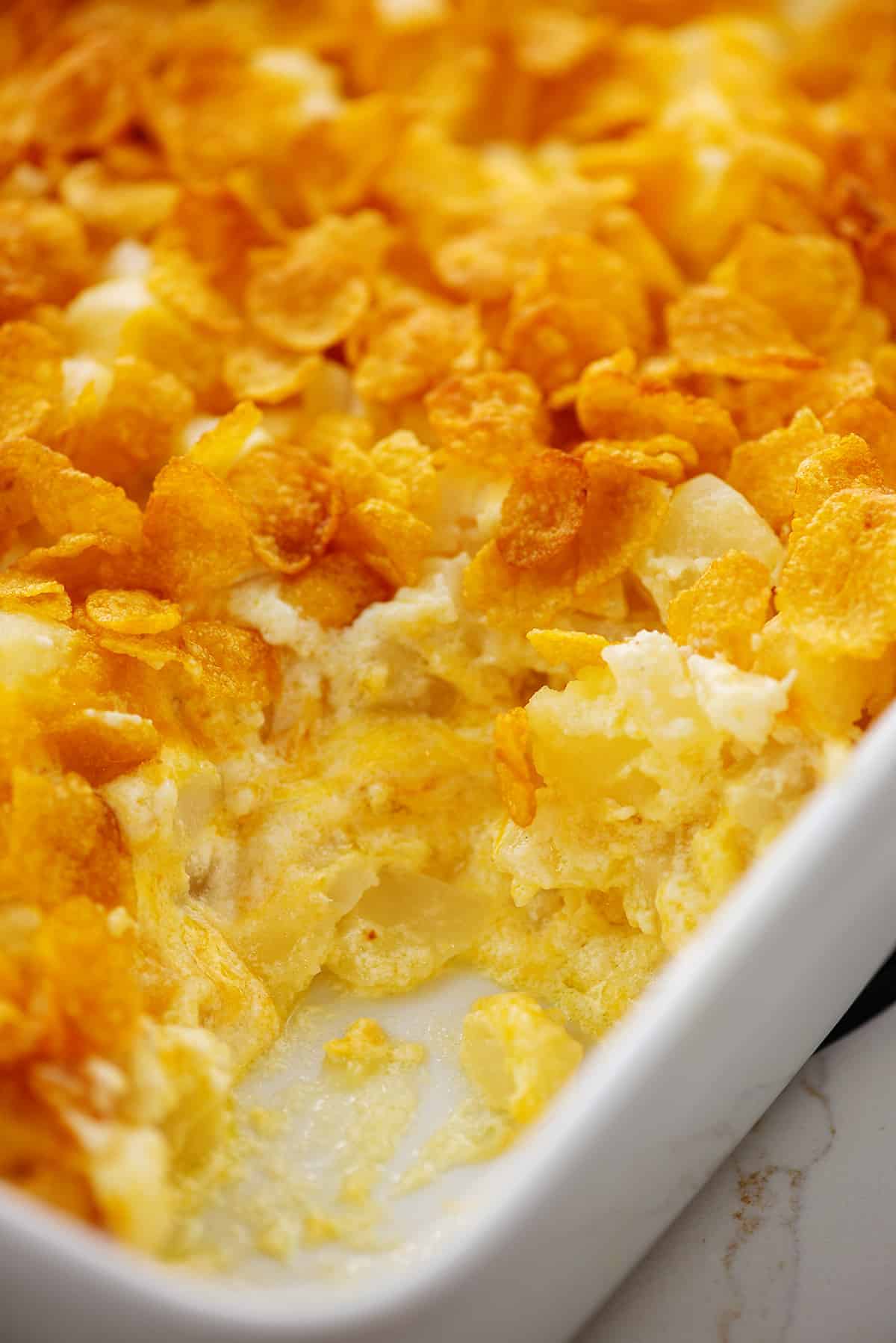 cheesy funeral potatoes in white baking dish.