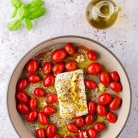 cherry tomatoes and feta cheese in baking dish.